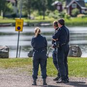 Poliser och polishundar undersöker det området där kvinnan hittats död.