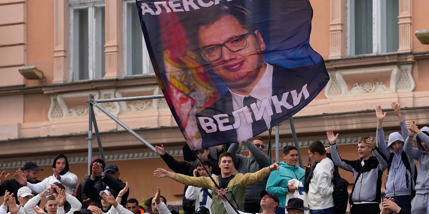 Anhängare till Serbiens president Aleksandar Vucic håller upp en flagga med hans porträtt under ett valmöte i Novi Sad på fredagen.
