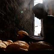 En bagare lägger upp tunnbrödet baladi utanför ett bageri i Kairo. Bröd har en central plats i både den egyptiska kulturen och ekonomin.