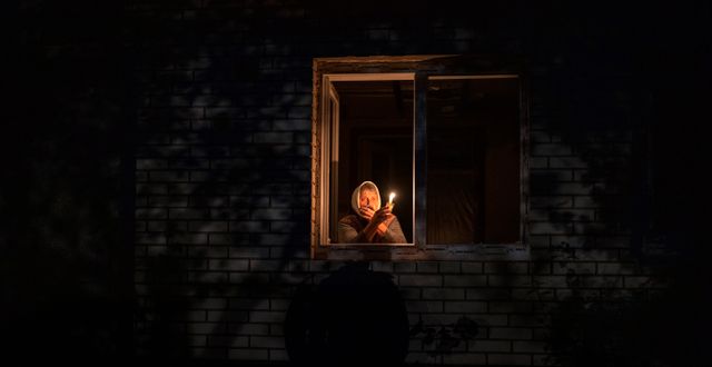 70-åriga Catherine med ett ljus i handen under ett strömavbrott i Kyiv den 20 oktober.  Emilio Morenatti / AP