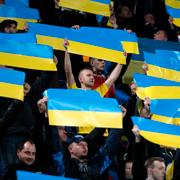 Fotbollsfans håller i ukrainska flaggor.