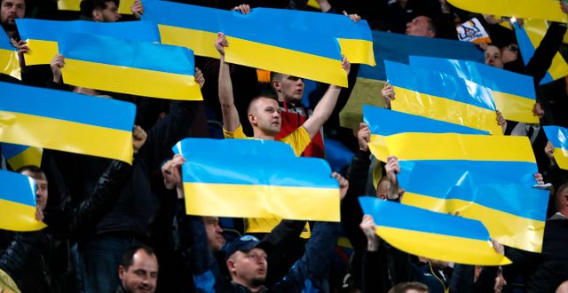 Fotbollsfans håller i ukrainska flaggor. GLEB GARANICH / BILDBYRÅN