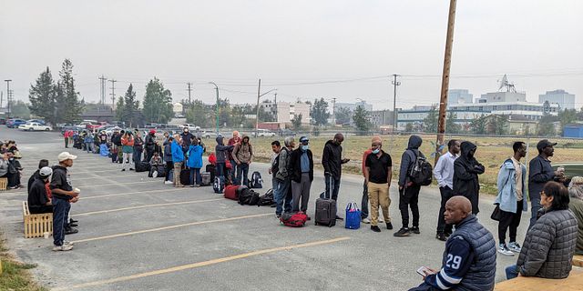 Människor i Yellowknife köar för att registrera sig för ett evakueringsflyg bort från den brandhärjade staden. I / AP