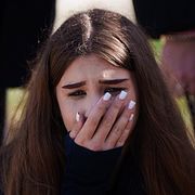 En flicka gråter vid sin 14-åriga väns grav efter en attack i Kyivregionen.