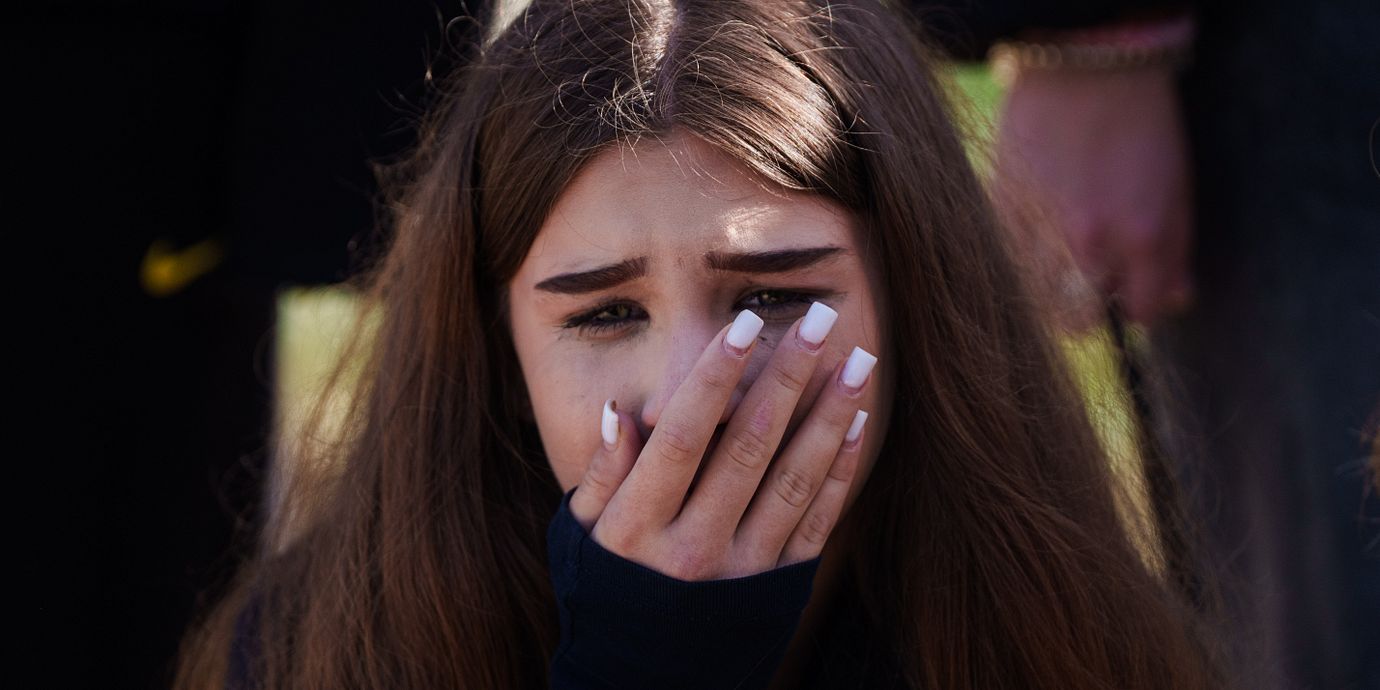 En flicka gråter vid sin 14-åriga väns grav efter en attack i Kyivregionen.