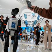 En Booster T1-robot från Booster Robotics välkomnar besökare på Zhongguancun Forum i Peking den 28 mars 2025.