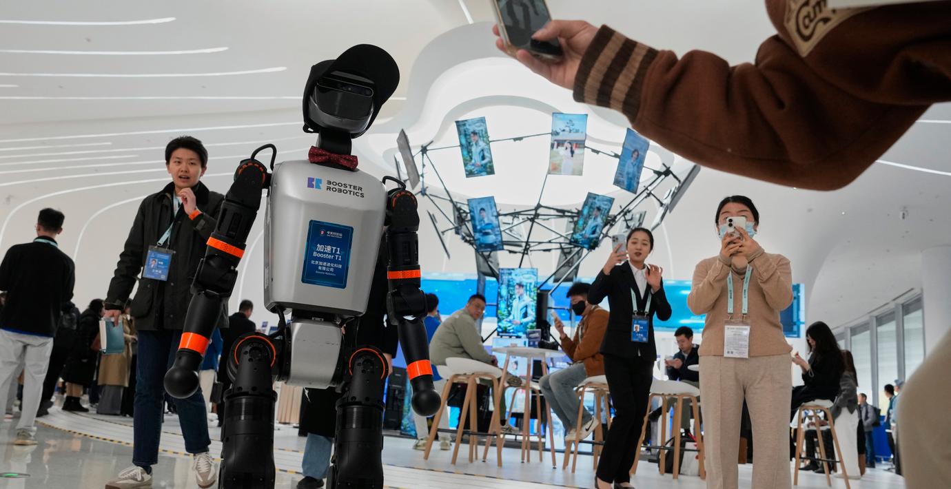 En Booster T1-robot från Booster Robotics välkomnar besökare på Zhongguancun Forum i Peking den 28 mars 2025.