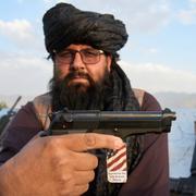 En talibankrigare visar en amerikansk pistol medi Kabul i Afghanistan. 