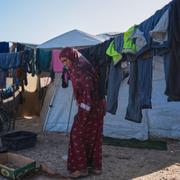 Amal Mahmoud, 36, hänger kläder på tork i Gaza där vintersäsongen kommit med regn och översvämningar bland tälten.