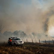 Brandmän försöker släcka en markbrand utanför Rom.