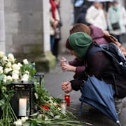 Människor vid en minnesstund i Zürich för offren i branden. 