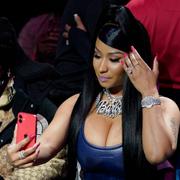 Nicki Minaj tittar i telefonen under en baseballmatch 2022. 