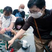 En barnfamilj tänder rökelse på årsdagen av atombomben i Hiroshima.