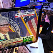 Illustrationsbild. Investerare med Fed-chefen Jerome Powell på skärmen.