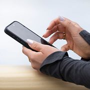 Två personer läser på sina telefoner.