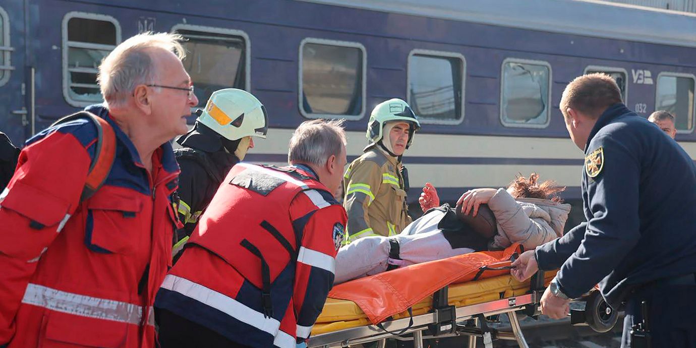 Räddningsarbetare hjälper en skadad civilperson efter den ryska drönarattacken mot en tågstation i Dnipro. Bilden kommer från den ukrainska räddningstjänsten.