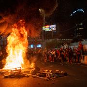 Människor blockerar en väg i Tel Aviv i samband med demonstrationen på söndagskvällen.