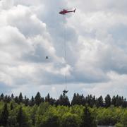 Helikopter bärgar vrakdelar efter olyckan.