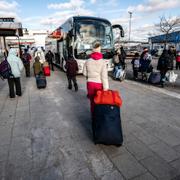 Ukrainska flyktingar på väg mot väntande bussar efter ankomst till hamnen i Karlskrona i mars.