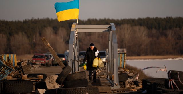 En kvinna korsar en delvis förstörd bro i Ukraina.  Vadim Ghirda / AP