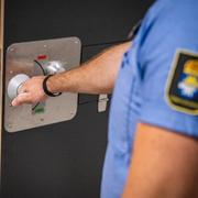 Kriminalvårdare öppnar dörren till en häktescell.