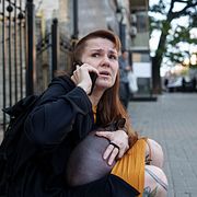 En kvinna ringer ett telefonsamtal efter en rysk drönarattack mot centrala Kyjiv, 28 september 2026.