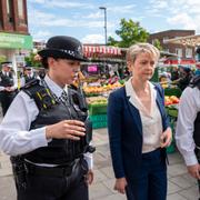 Inrikesminister Yvette Cooper tillsammans med två poliser. 