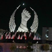 En man med cykel passerar ett monument i Teheran.