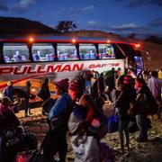 Venezolanska migranter vid en buss som ska ta dem till gränsen mellan Ecuador och Peru. 