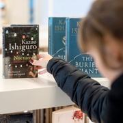 En kvinna tittar på böcker av den engelska författaren Kazou Ishiguro, som vann Nobelpriset i litteratur 2017.