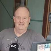 Bombskyddens robot på plats på adressen i Malmö. TIll höger Mikael Bard som intervjuas av SVT med termosen i hand. 