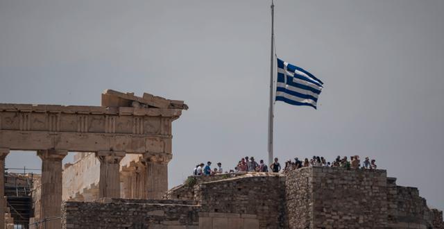 Den grekiska flaggan vajar på halv stång vid Parthenon-templet efter katastrofen. Petros Giannakouris / AP