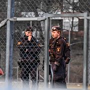 Polis på plats vid fotbollsplanen där en man hittades skjuten i Vårby Gård i Huddinge.