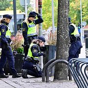 Poliser söker av området runt brottsplatsen i oktober.