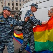 Arkivbild på ryska poliser som konfiskerar en pride-flagga.