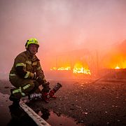 En brandman som arbetar med att släcka en brand efter ryska attacker i Kiev.