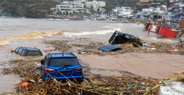 Bilar har svepts ut i vattnet på Kreta.  Harry Nakos / AP