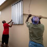 Puertoricaner som försöker stormsäkra sitt hus. 