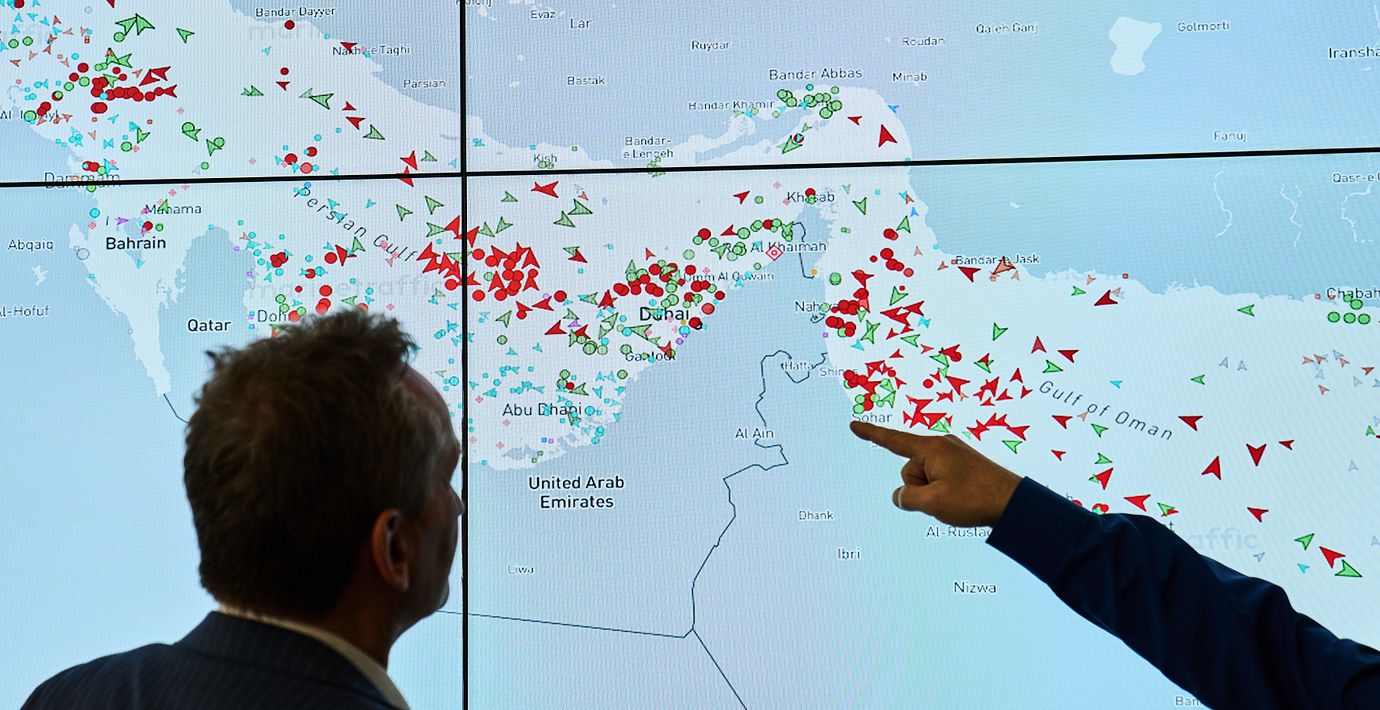 Två män studerar en karta över fartygstrafiken kring Hormuzsundet utanför Iran på torsdagen.