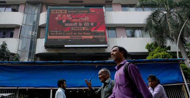 En tv-skärm visar ett nyhetsinslag om Adani Group utanför Bombaybörsen, 27 januari 2023.  Rajanish Kakade / AP