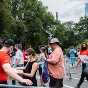 Människor visar vaccinationsbevis på väg in till konserten.