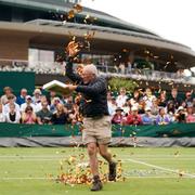 En ”Just Stop Oil” aktivist slänger konfetti under en pågående tennismatch i Wimbledon.