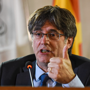 Carles Puigdemont på en arkivbild och en vägkontroll upprättad av spansk polis under jakten på separatistledaren tidigare i augusti. 