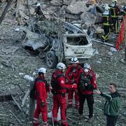 Brandmän och sjukvårdare i arbete efter nattens drönarattack mot Kyiv. 