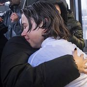 Anhöriga till offer i branden kramas.