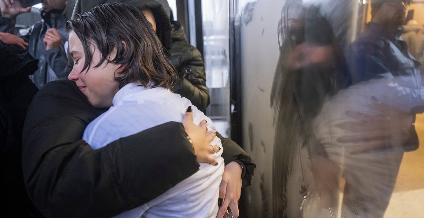 Anhöriga till offer i branden kramas.