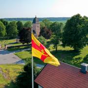 Yttergrans kyrka i Uppland. En flagga från Svenska kyrkan i förgrunden.