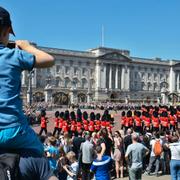 Turister tittar på vaktbytet vid Buckingham Palace i London på fredagen.