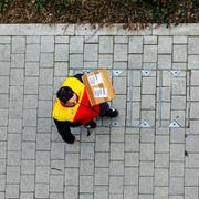 En medarbetare hos DHL levererar ett paket.