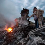 Personer inspekterar platsen där MH17 kraschade i juli 2014.